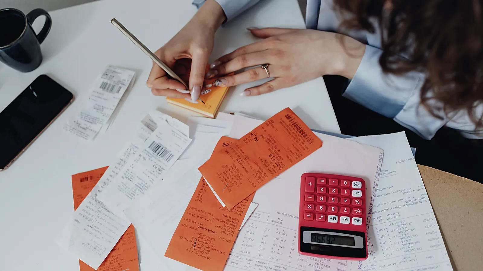 Receipts and a calculator spread across a desk during bookkeeping
