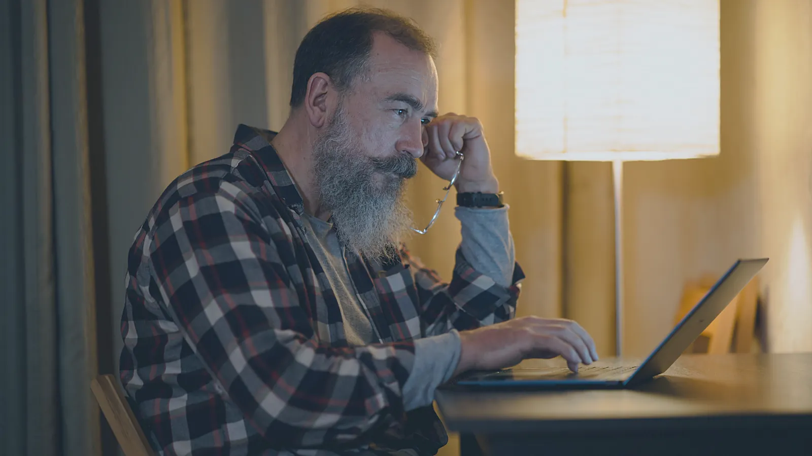 Business owner checking numbers on a laptop late at night