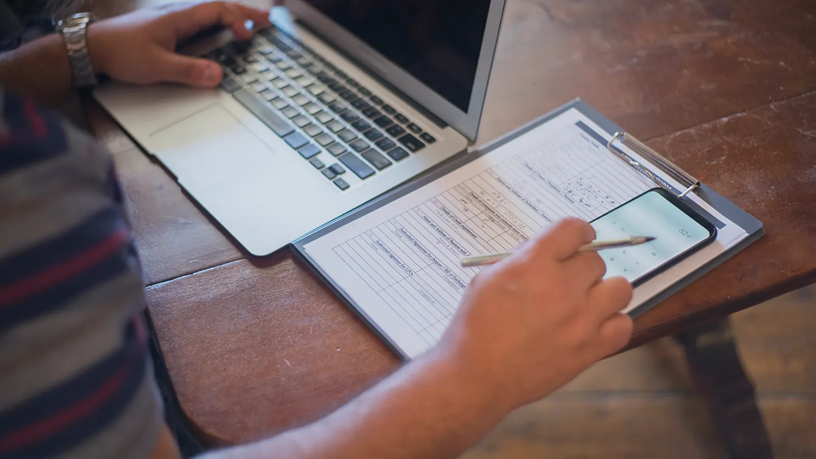Owner comparing a printed report with numbers on a laptop