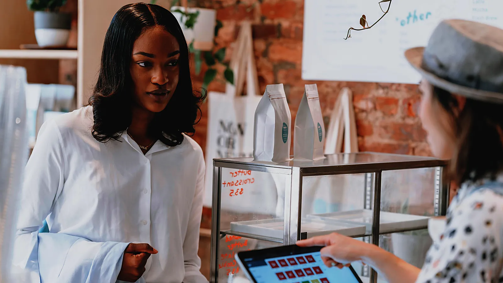 Cafe owner ringing up a customer on a tablet register