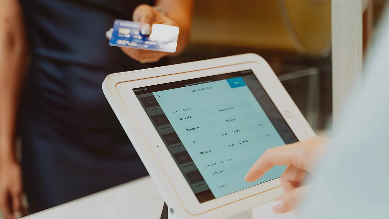 Close-up of a tablet register screen at a cafe counter